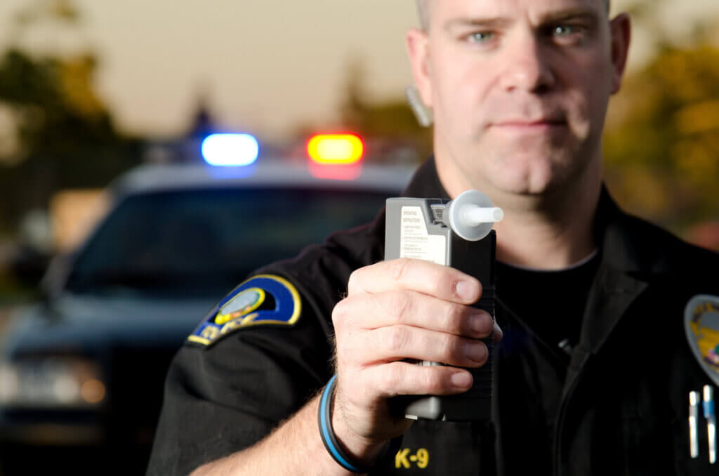a policeman holding a breathalyzer